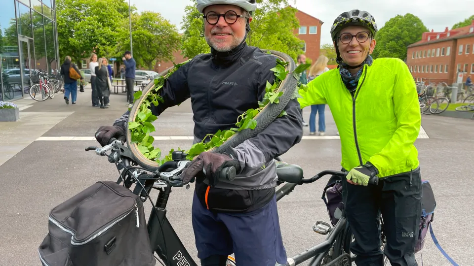Man med krans om halsen och kvinna på tandemcykel