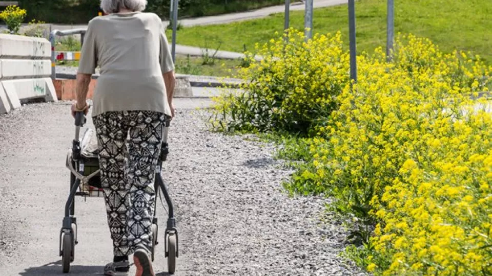 äldre kvinna går med rollator