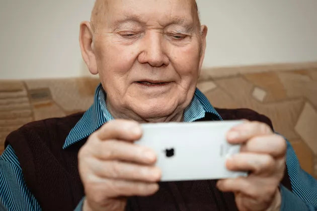en äldre man med mobiltelefon. foto
