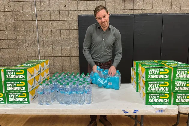 Man ställer upp flaskor med vatten på ett bord