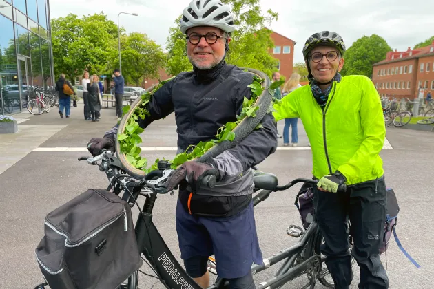Man med krans om halsen och kvinna på tandemcykel