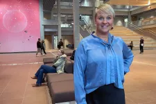 Anna Tenje i blå blus framför rosa konstvägg på BMC i Medicum Forum.