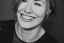 Svartvit porträttbild på en glad Christina Heller.