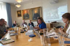 Forskare sitter vid bord och diskuterar