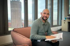 Man sitter i fåtölj och bläddrar i avhandling