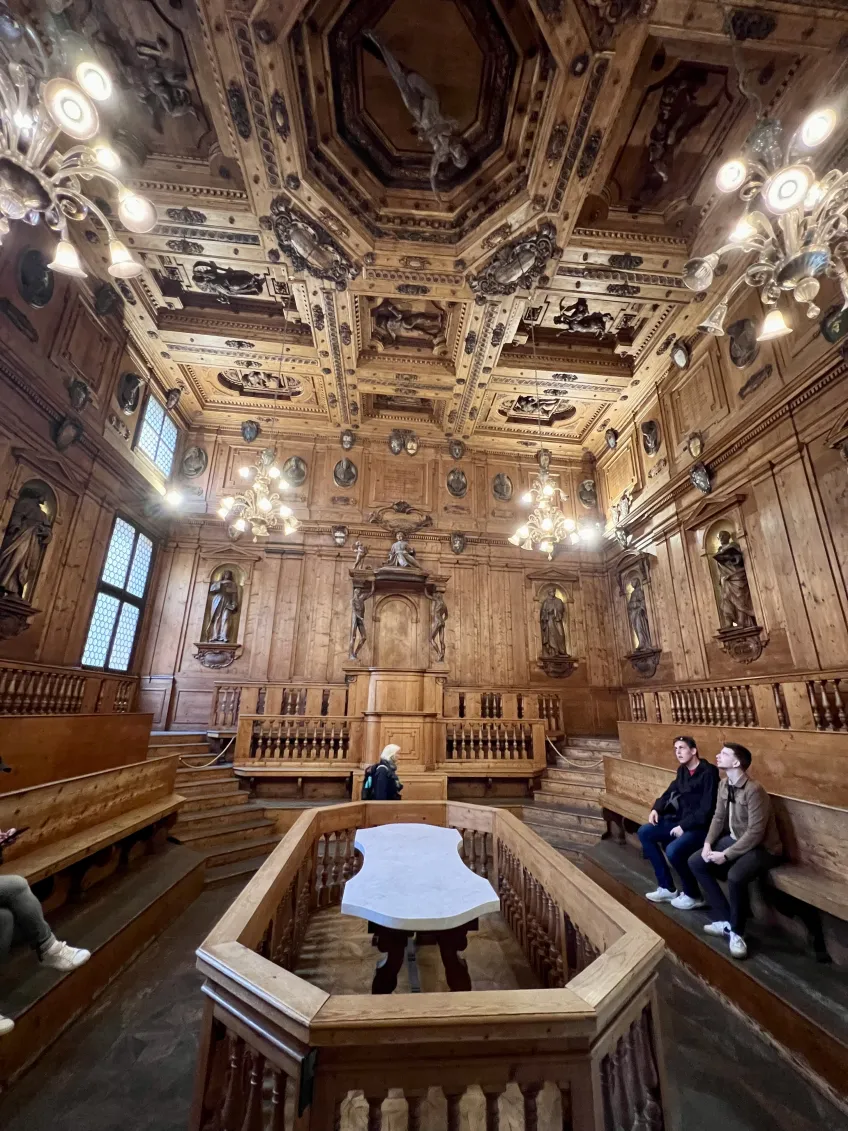 Två personer sitter i Anatomiska teatern i Archiginnasio-palatset i Bologna.
