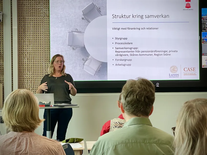 Kvinna föreläser inför sittande publik
