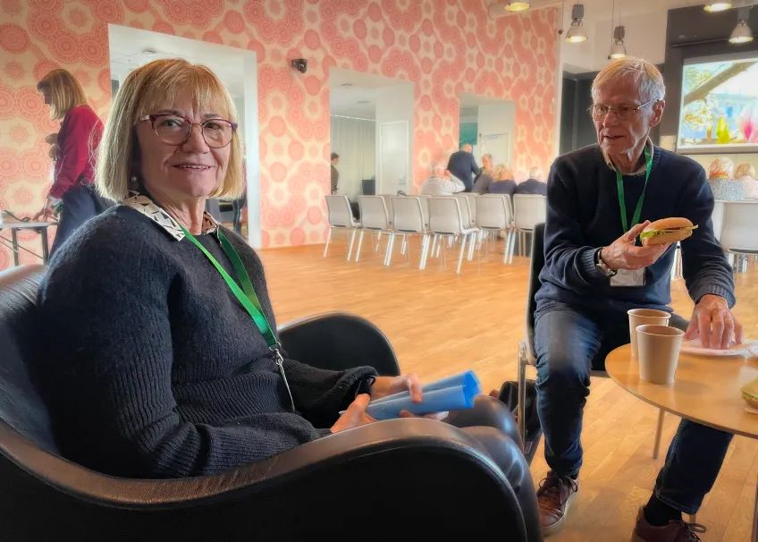 Kvinna sitter och fikar brevid en man.