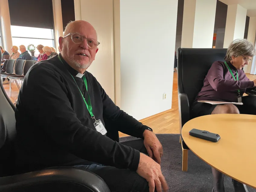 Präst sitter vid ett bord brevid en kvinna